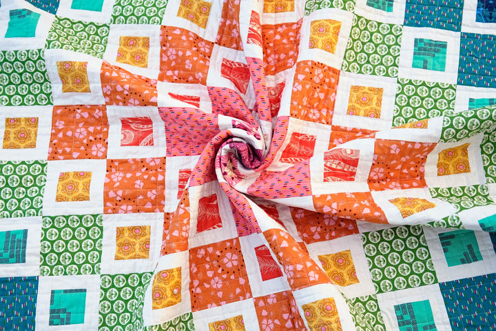 Completed Frances Quilt Pattern featuring a colorful rainbow design made with squares and bordered squares.