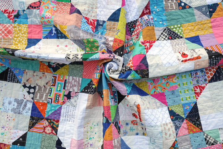 Colorful fabric scraps and quilt blocks arranged on a sewing table, showcasing the creative use of leftover materials in quilting.